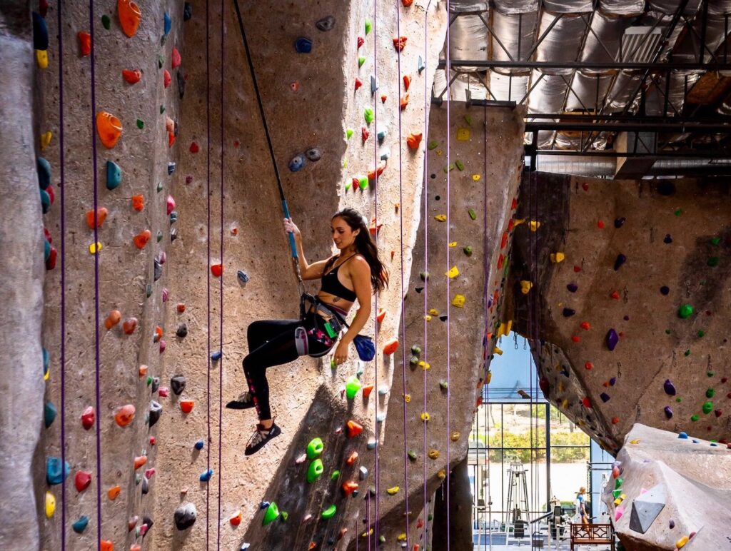 Rock climber repelling in Vertical Hold indoor climbing gym